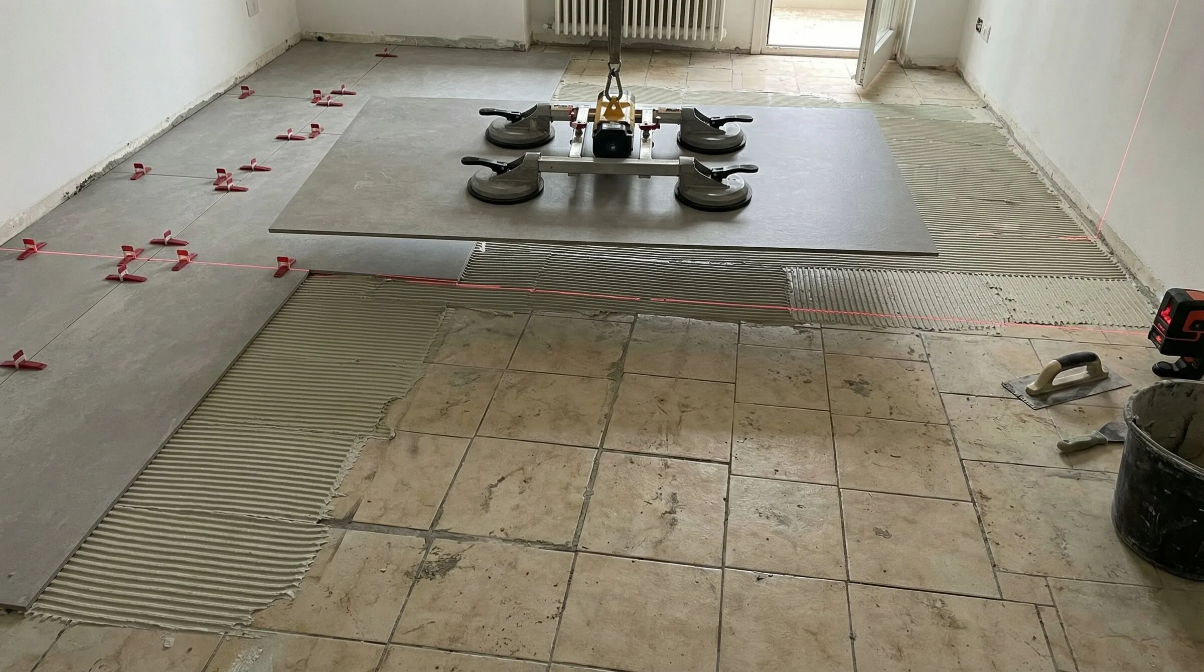 專業施工人員使用大型吸盤搬運 120x260cm 大板薄板,準備於舊有地磚上進行覆蓋施工